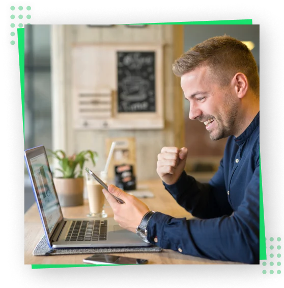 a person with laptop looking at his phone